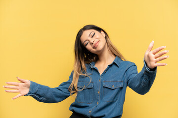 Young Russian girl isolated on yellow background presenting and inviting to come with hand