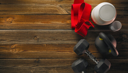 Fitness equipment and supplements top view on wooden floor copy free space. Mock-up. Sports bodybuilding supplements and nutrition. - obrazy, fototapety, plakaty