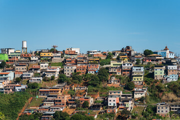 Fototapeta na wymiar Colorful Favelas on Hillside under Clear Blue Sky with Space for Text