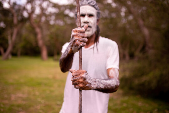 Dharawal man with a painted face holding a spear