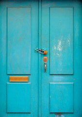 Turquoise wooden door with a padlock