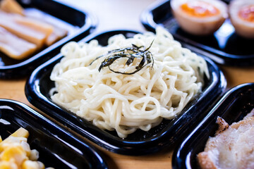 Fresh ramen noodles placed in a black tray