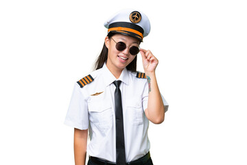 Airplane pilot Asian woman over isolated background with glasses and happy