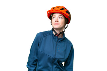 Young cyclist woman over isolated chroma key background and looking up - obrazy, fototapety, plakaty