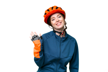 Young cyclist woman over isolated chroma key background saluting with hand with happy expression