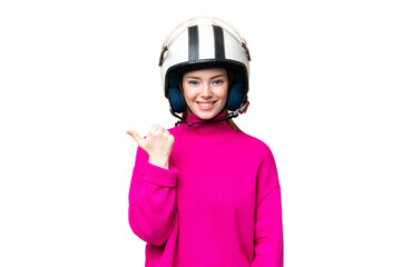 Young pretty woman with a motorcycle helmet over isolated chroma key background pointing to the side to present a product