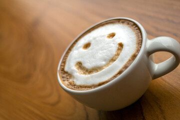 Cup of cappuccino coffee delicious hot coffee with foam milk and smile on color background, top view. Happy morning, good mood, inspiration