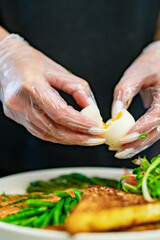 woman chef hand cooking salmon, green bean, olive, salad and soft boiled egg