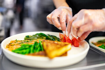 woman chef hand cooking salmon, green bean, olive, salad and soft boiled egg