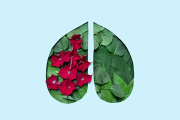 creative image human lungs shape on blue background made from fresh green foliage.