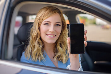 Attractive woman showing smartphone out the window of a car.