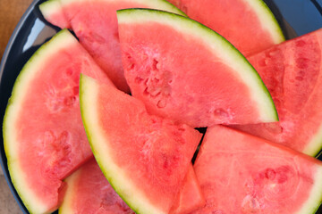 Fresh sliced red watermelon with green skin for use as a summer background