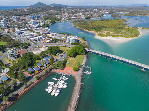 Aerial view of a river flowing out past a marina and city buildings