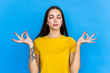 Young woman over blue background in zen pose