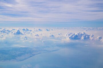 The Aerial view of Fluffy clouds Top view from airplane window, Nature background. - obrazy, fototapety, plakaty