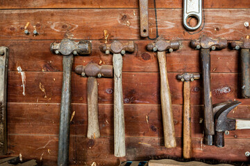 Assorted hammers hanging on wall in farm shed