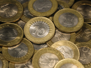 a mixed collection of rare vintage indian bimetallic 10 (ten) rupee coins gold and silver in a pile
