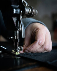 mano sosteniendo prenda en una maquina de coser