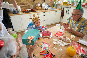 Little Girl's Birthday Joy Surrounded by Grandma, Grandpa, and Mom