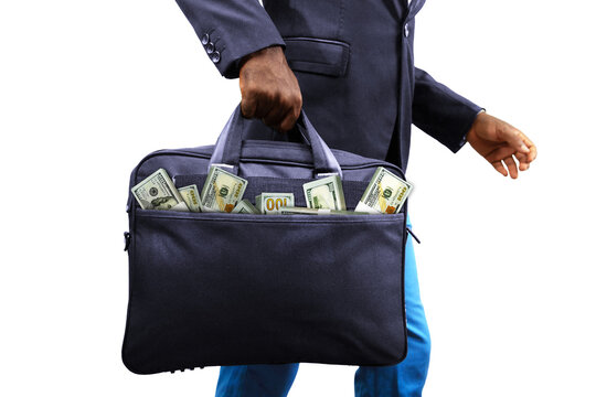 Black African Businessman holding black bag full of stacks of US dollar notes isolated on white background, money coming out of bag. Person carrying bag containing money