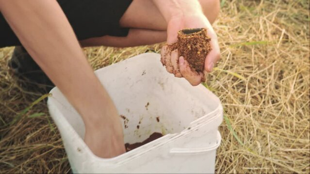 River and lake fishing for large freshwater fish. Feeder fishing. Male hands Filling the feeder basket with bait