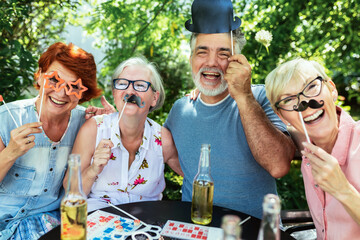 Elderly people making themselves young again with silly glasses, hats and mustaches