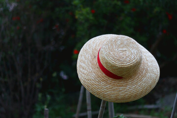 Straw hat hanging in the garden. Selective focus.