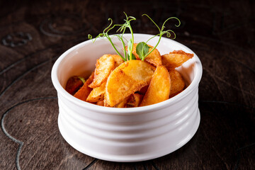 Potato country style fried in bowl on wooden table