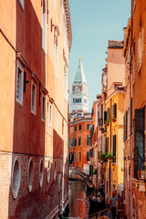 gondolas gracefully glide through narrow canals, weaving past vibrant, colorful houses, creating a captivating scene in the charming city of Venice Italy