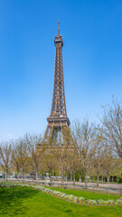 Eiffel Tower on sunny spring day. View from green lawn on Champs de Mars. Paris, France