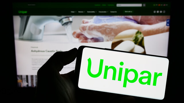 Stuttgart, Germany - 06-18-2023: Person holding cellphone with logo of Brazilian company Unipar Carbocloro S.A. on screen in front of business webpage. Focus on phone display.