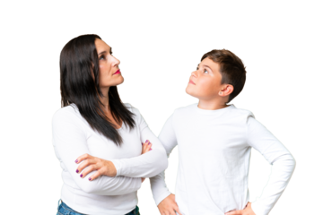 Little caucasian kid over isolated chroma key background looking up while smiling