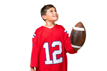 Little caucasian kid playing rugby over isolated chroma key background looking up while smiling