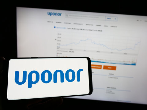 Stuttgart, Germany - 06-18-2023: Person holding mobile phone with logo of Finnish water technology company Uponor Oyj on screen in front of web page. Focus on phone display.