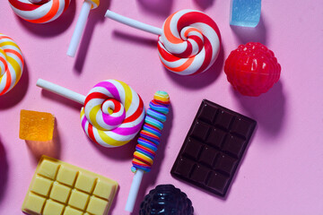 Flat lay sweet candy favorite of small children. Colorful lollipops, candies, chocolates. Pink...