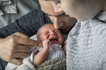 Newborn baby colic close up. Young parents and crying baby 1 month old - Powered by Adobe