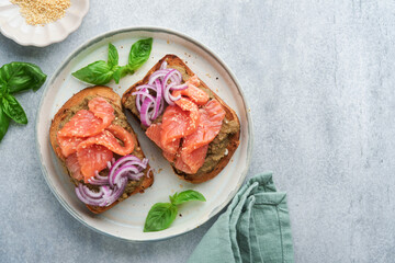 Sandwiches with salted salmon, avocado guacamole, red onions and basil. Smorrebrod. Set of danish open sandwiches. Healthy food, breakfast. Clean eating, dieting, vegan food concept. Top view.