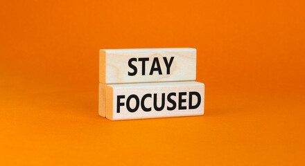 Stay focused symbol. Concept words Stay focused on wooden blocks on a beautiful orange table orange...