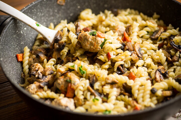 vermicelli cooked with mushrooms, meat and vegetables in a frying pan