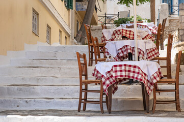 Restaurant Tables and Chairs placed on the Steps between Buildings in the Plaka Area of Athens Greece