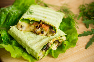 green hot vegetarian pita bread with mushrooms and different vegetables, with lettuce leaves .
