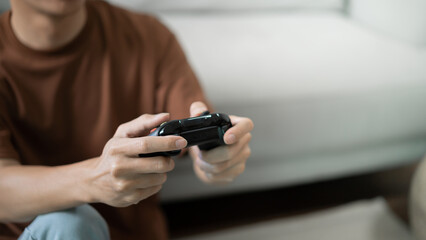 Young Asian man gamer controller video console playing holding hobby playful Online Video Game enjoyment eSport Cyber Games Internet. © Charlie's