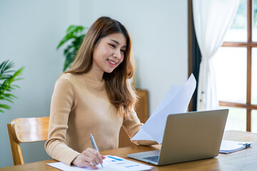 Happy beautiful Asian Woman. Business woman working from home with laptop Financial Home work space concept.