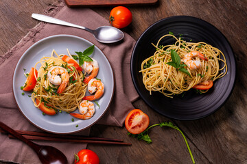 Stir-fried spaghetti or stir-fried noodles Tomato sauce and prawns on a plate and tomato basil on...