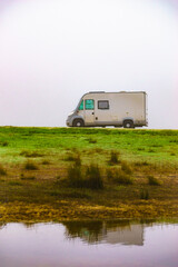 Camper rv camping at lake shore. Foggy day