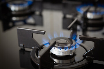 Gas supply chain, global gas crisis and price rise concept. Gas cooker with burning flames of...