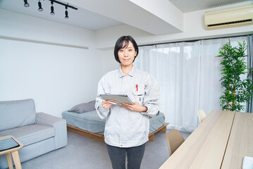部屋を確認する作業着姿の女性
