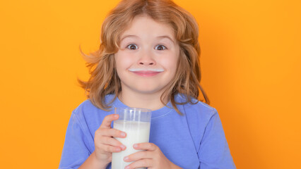 Organic milk. Little boy drinking milk. Child with glass of milk on yellow isolated background.
