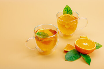 Orange tea in glass cups with ripe fruits. Refreshment seasonal drink, conceptual background