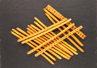 Straw is a bakery product. A few straws on a slate stone, macro, top view.